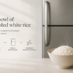 A bowl of cooled white rice next to a refrigerator, representing resistant starch conversion